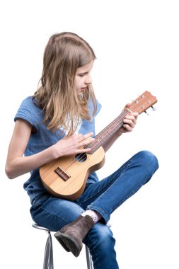 Mavi tişörtlü genç, sarışın kız ukulele enstrümanında oturuyor ve konser veriyor..