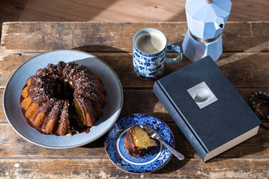 Lezzetli bir dilim Paskalya pastası, iyi bir kitap ve eski, siyah ahşap masada sıcak kahve - güzel bir öğleden sonra..