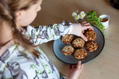 Kız, evde otururken, lezzetli, hazırlığı kolay ve sağlıklı ev yapımı daha iyi yemek kurabiyeleri yapıyor..