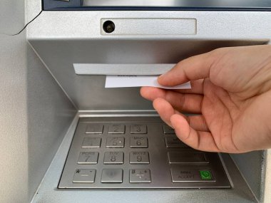 Bir kadın ATM 'den makbuzu alıyor.