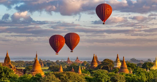 Bagan, Myanmar 'da Sunrise' da renkli antik tapınakların üzerinde 3 Kırmızı Sıcak Hava Balonu