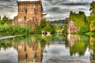 İtalya Kalesi üzerindeki dramatik bulutlar bir nehirde yansıyor