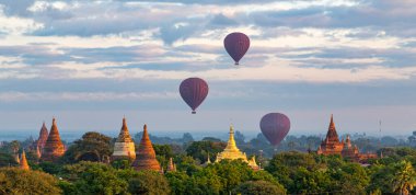 Bagan, Myanmar 'da Sunrise' da renkli antik tapınakların üzerinde sıcak hava balonları
