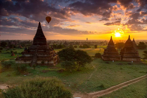 Güneş doğarken sıcak hava balonları Bagan, Myanmar 'da tapınakların üzerinde uçuyor.