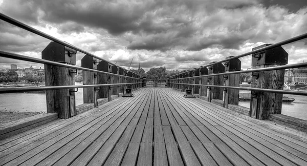 Peer on River Thames in London with dramatic skies