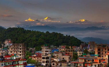 Gün batımında arka planda Annapurna sıradağları ile Pokhara şehir manzarası
