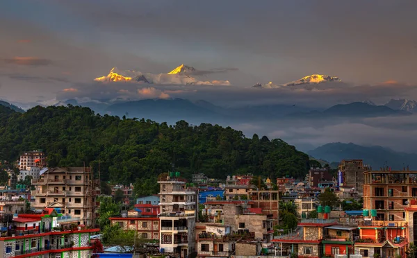 Gün batımında arka planda Annapurna sıradağları ile Pokhara şehir manzarası