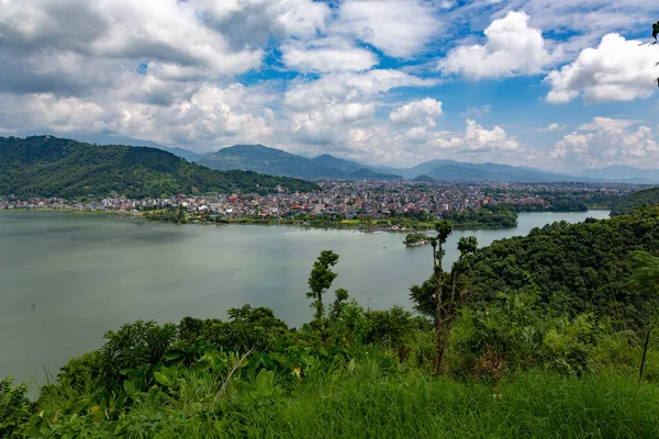 Yeşil orman ve beyaz bulutlarla Pokhara şehri ve göl manzarası