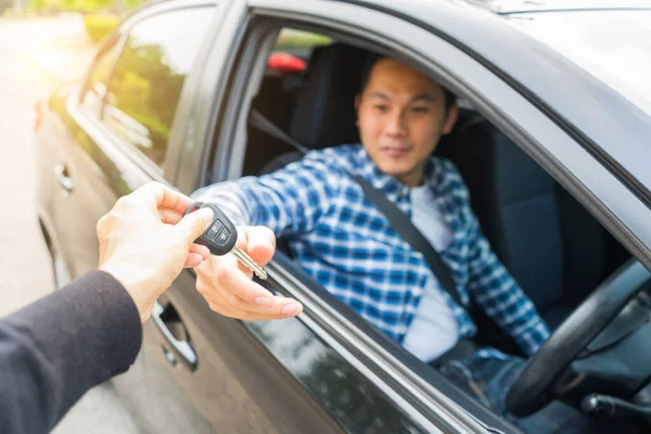 若いアジア人の男が車の鍵を手に入れた レンタカーまたはレンタカーの概念 — ストック写真