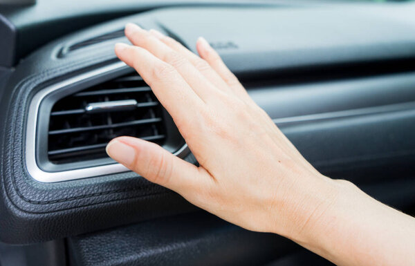 Closeup of hand checking the air conditioner system in the car.