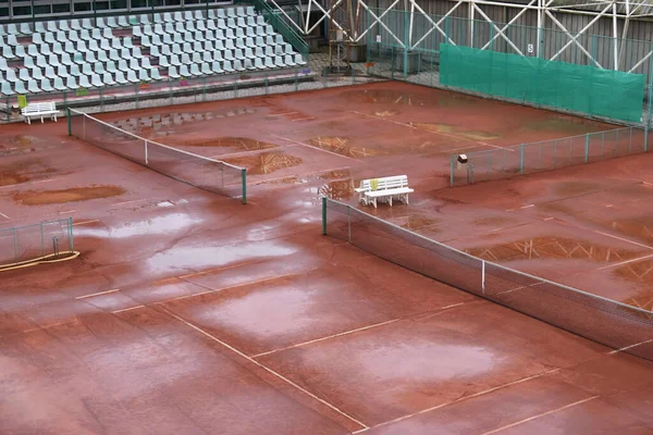 Yağmurdan sonra çamurlu tenis kortu ve su birikintileri, toprak suyu ememez, maç iptal! Sonbahar sezonu bitti. Açık mahkemenin dezavantajı kullanım mevsimidir..