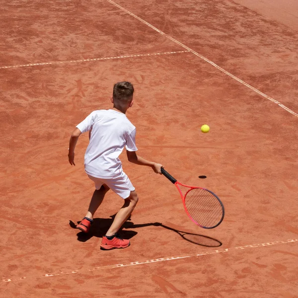 Junge Spielt Tennis Auf Einem Sandplatz Kind Ist Konzentriert Und — Stockfoto