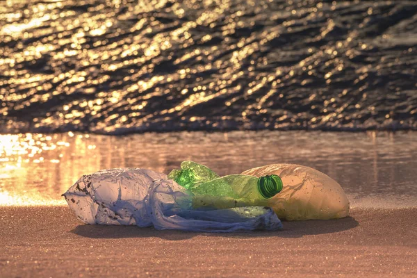 Plastikowa Butelka Torby Wybrzeżu Wspaniała Fala Morska Złotym Świetle Świtu — Zdjęcie stockowe