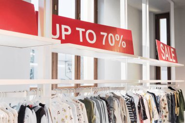 Satış promosyonu, Kara Cuma ve alışveriş konsepti. Alışveriş merkezinde kırmızı yüzde 70 indirimli fiyattır. Arka planda elbise askısı var. Seçici odak