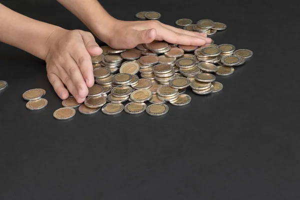 小孩的手在黑色背景上移动硬币 节约资金 新的财务机会 早期投资的概念 复制空间 — 图库照片