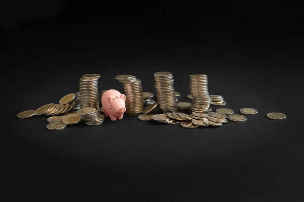 黑色背景的皮吉银行和硬币 粉红钱箱和钱储蓄 财务机会概念 复制空间 — 图库照片