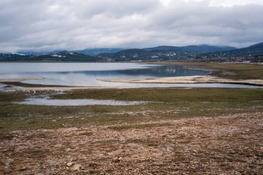 Bulgaristan 'ın Rodop Dağları' ndaki Batak Barajı 'nın baharın başlarında kısmen sular altında kalan kıyı şeridi manzarası. Batak Barajı Dağı Gölü.