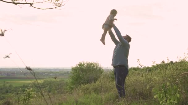 Feliz, pai na montanha joga seu filho para cima — Vídeo de Stock