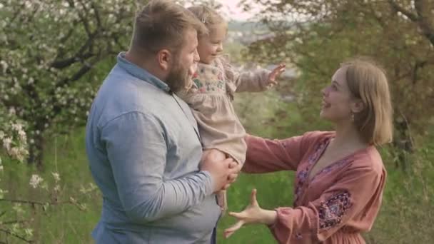 Bahçedeki genç mutlu aile. Karizmatik hamile bir eş ailesi için sevinir., — Stok video