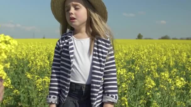 Маленька красива алергія дівчина чхає в жовтому квітковому полі — стокове відео