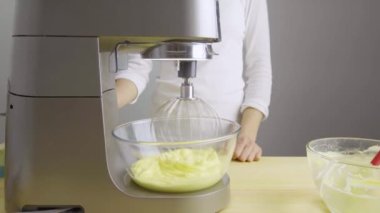 Mutfaktaki kız mutfak makinesinde krem şanti yapıyor..