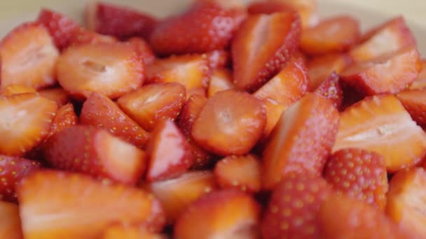 Αργή κίνηση. Κοντινό πλάνο. φράουλες σε φέτες πέφτουν σε πιάτο. — Αρχείο Βίντεο