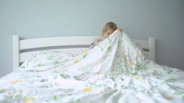 Lilla flicka i pyjamas går till sängs med sin leksak kanin, — Stockvideo