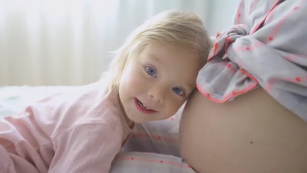 Close-up. menina ouvindo como o bebê chutando dentro da barriga das mães. 40 semanas de gravidez — Vídeo de Stock