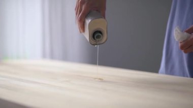 Ağır çekim. Ahşap. Usta, ahşap bir masaya yağ döker..