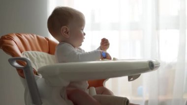 Yan görüş. Küçük çocuk bebek maması yiyor..