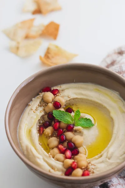 Üstünde nar tohumları olan ev yapımı humus sosu.