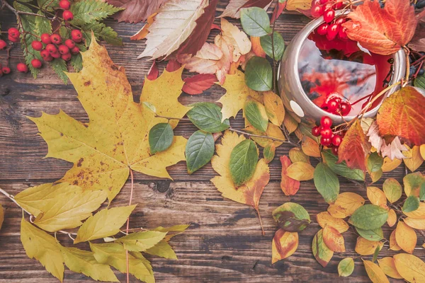 Sonbahar sarı ile ahşap bir masa üzerinde sıcak çay iskele fincan ve