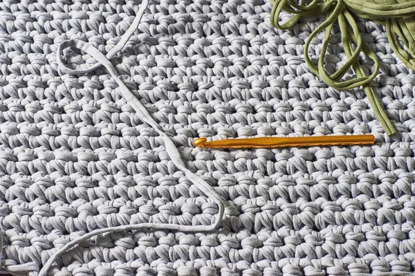 hook for knitting against the backdrop of a knitted carpet