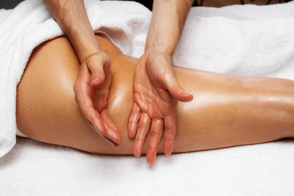 Male hands making anti-cellulite foot massage for woman. Slimming legs and hips