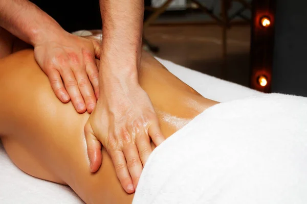 Male hands making massage for woman back. Oil massage. Thai oil massage close up. Back massage. Spa treatments.