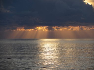 Gökte devleri kümülonimbus bulutlar ve güneş ışınları ile Sıcak deniz gün batımı . Toskana, İtalya