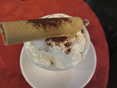 Bir fincan sıcak çikolata ile çırpılmış krem Tepesi ve gofret. Üstten görünüm