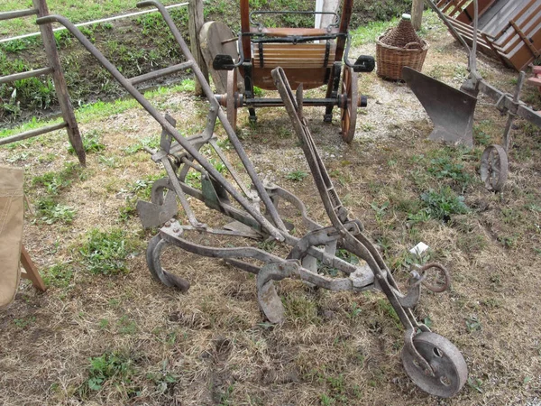 Alter Eisenpflug und andere landwirtschaftliche Geräte — Stockfoto