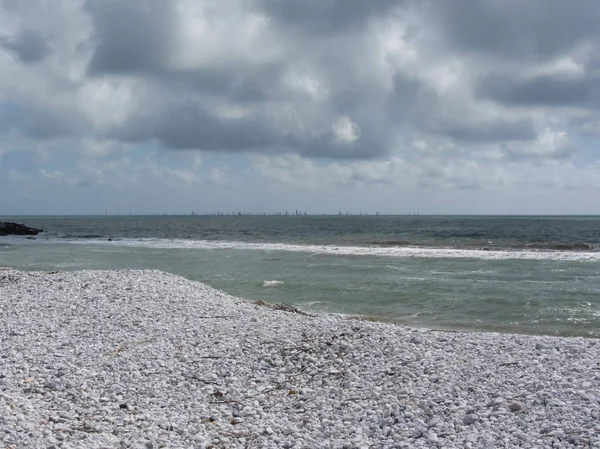 Узбережжя Марини ді Піза пляж з Вітрильники на горизонті в похмурий день на літо. Тоскана, Італія — стокове фото
