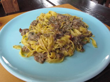 Mavi bir plaka üzerinde porcini mantar ile İtalyan taze fettuccine veya tagliatelle makarna