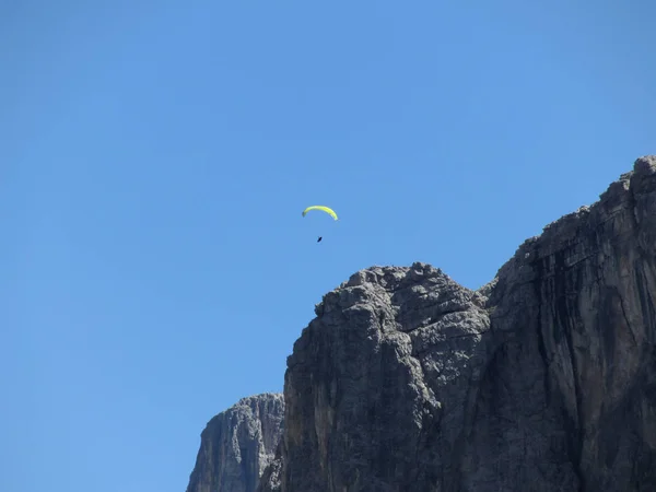 Parapente con su paracaídas amarillo volando cerca de las altas montañas italianas. Dolomitas, Italia — Foto de Stock