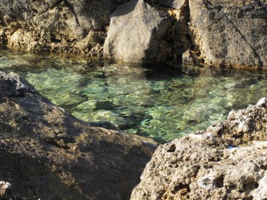Kayalar arasında kristal berraklığında deniz suyu . Toskana, İtalya
