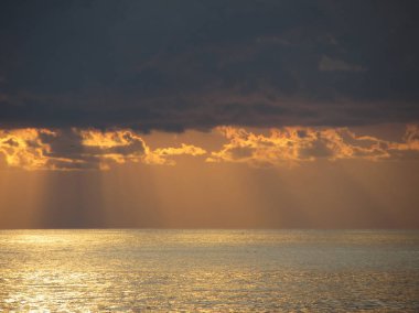 Gökte devleri kümülonimbus bulutlar ve güneş ışınları ile Sıcak deniz gün batımı . Toskana, İtalya
