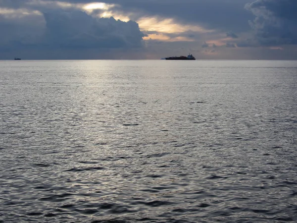 Meleg tengeri naplemente teherhajóval a horizonton. Giants Gomolyfelhő magasságban vannak az égen. Toszkána, Olaszország — Stock Fotó