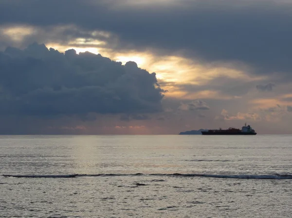 Meleg tengeri naplemente teherhajóval a horizonton. Giants Gomolyfelhő magasságban vannak az égen. Toszkána, Olaszország — Stock Fotó