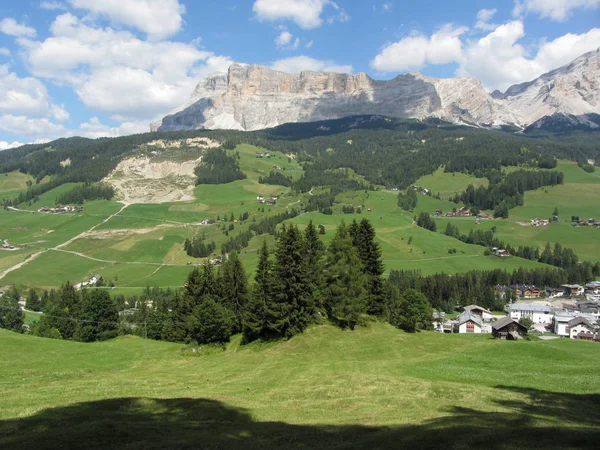 Alpine Landschaft mit Villendorf, grünen Weiden und Tannen gegen die italienischen Dolomiten im Sommer. la villa, bozen, alto adige, Südtirol, Italien — Stockfoto