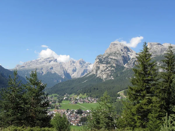 Alpine landscape with La Villa village, green pastures and firs against italian Dolomites at summer . La Villa, Bolzano, Alto Adige, South Tyrol, Italy