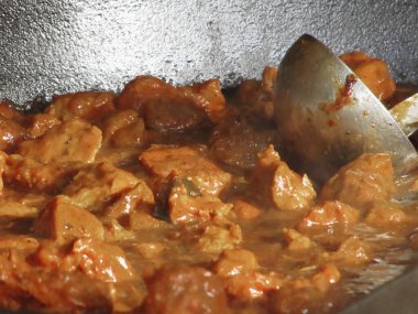 Metal servis kaşığıyla gulaş çorbası.