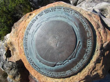 Metal plaka, Güney Afrika 'daki Cape Town' daki Masa Dağı 'nın tepesinden gelen 360 derecelik görüntüyü gösteriyor. Plaka, dağın zirvesinden görülebilecek her şeyi gösteriyor.