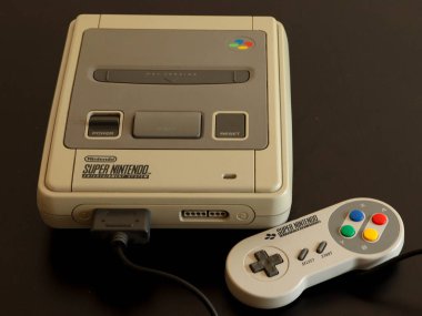 Milan, İtalya - 04 19 2020: Bir SNES (Süper NES olarak da bilinir) vodeogame karmaşası, kontrolörü ve biraz da Super Mario ile yakın plan. Konsolun tam adı Super Nintendo Eğlence Sistemi